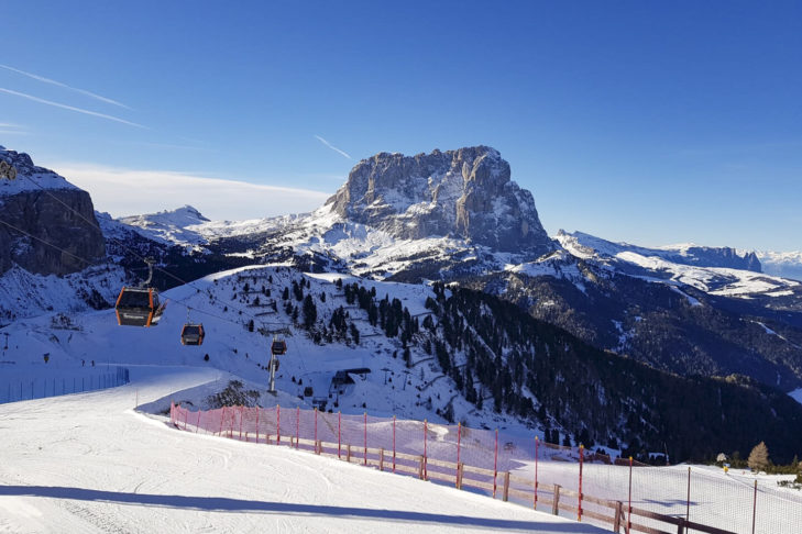 I giri di sci offrono divertimento sulle piste per molti chilometri contigui, come qui sulla Sellaronda di fronte alle imponenti cime rocciose delle Dolomiti.
